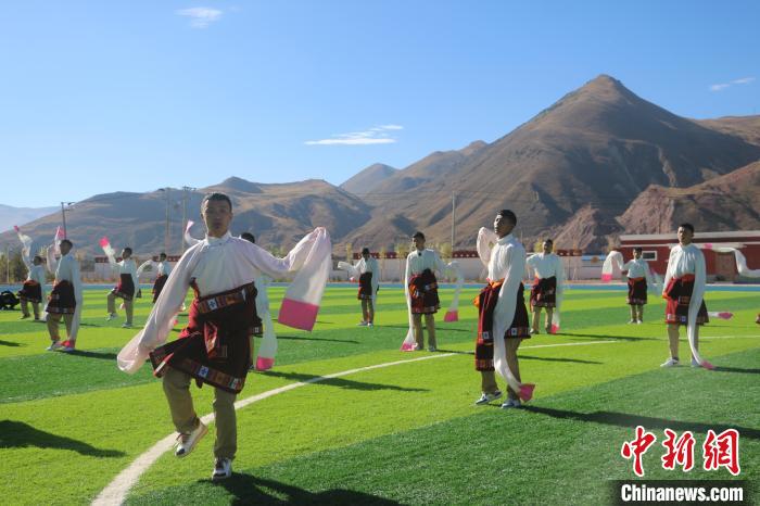 圖為青海師范大學(xué)附屬玉樹實(shí)驗(yàn)學(xué)校學(xué)生在綠茵場跳起囊謙古舞—卓根瑪?！〕逃?攝
