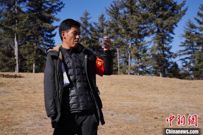 圖為桑杰加進(jìn)行巡查并拍照記錄?！●R銘言 攝