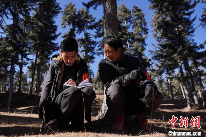 圖為桑杰加(左)和同事記錄巡查結(jié)果?！●R銘言 攝