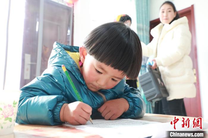 孩子們?cè)诩议T口上學(xué)，是楊周馬草搬入蘭州新家最為開心的事情。小女兒楊洋正在學(xué)習(xí)寫數(shù)字?！∥航ㄜ?攝
