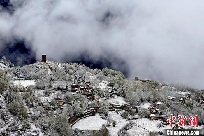 雪后的藏寨和碉樓構(gòu)成美麗的雪景?！〗党鯘衫?攝