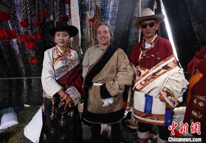 圖為一名外籍?dāng)z影師(中)身穿藏服和藏族民眾合影留念。　馬銘言 攝