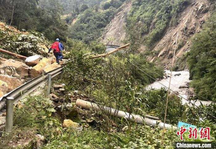 電力搶險人員快速通過危險路段，旁邊是受損的電力線路 四川電力供圖