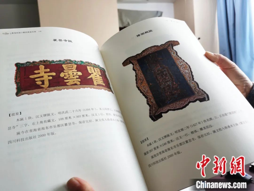 古籍保護(hù)人員展示介紹明代朱元璋撰寫的青海瞿曇寺匾(左)的出版書籍。張?zhí)砀?攝
