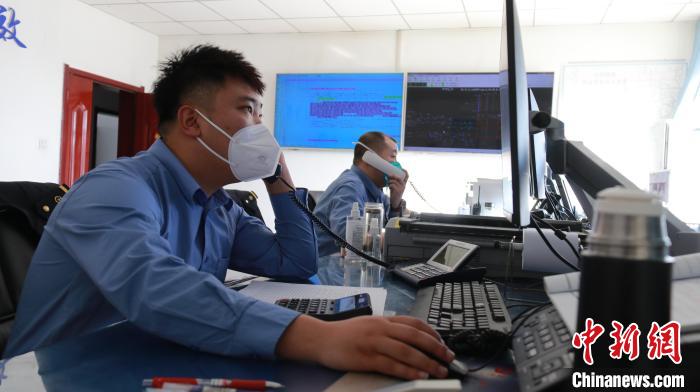 圖為貨運(yùn)調(diào)度人員與外勤工作人員聯(lián)系掌握車輛裝載情況?！±钌?攝