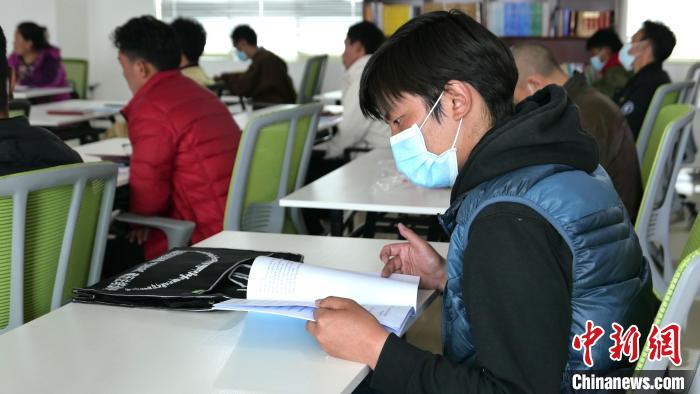 圖為正在閱讀“杰松達孜”藏歷法教材的學員?！≈x牧 攝