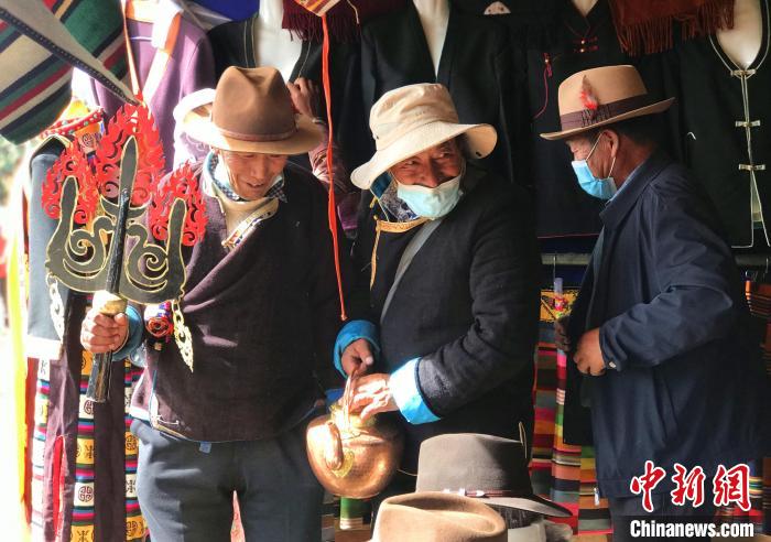 圖為三位藏族老人在集市上聊天交談?！∪轿木?攝