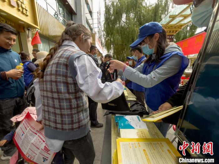 圖為志愿者為市民發(fā)放網(wǎng)絡(luò)安全宣傳手冊(cè)?！≈x牧 攝