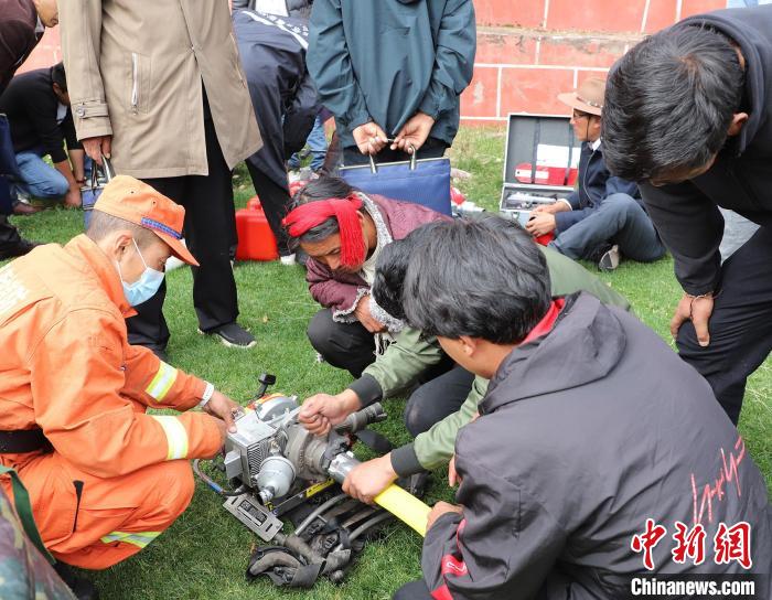 圖為森林消防員為護林員講解滅火裝備的使用方法?！〔际猩窒乐ш?供圖