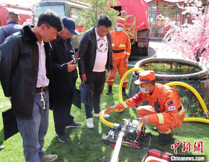 圖為森林消防員為護林員講解滅火裝備的使用方法?！〔际猩窒乐ш?供圖