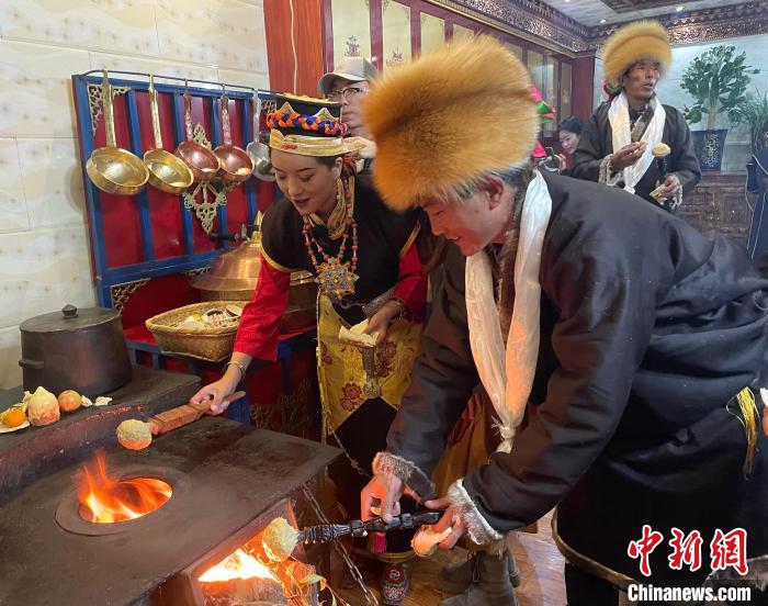 圖為人們?cè)诨鹕峡竟?jié)日美食“結(jié)達(dá)”?！∪轿木?攝