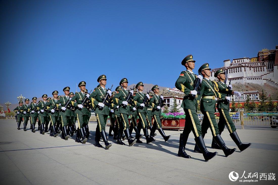 國(guó)旗護(hù)衛(wèi)隊(duì)隊(duì)員緊握鋼槍，踏著威武雄壯的步伐，走向國(guó)旗臺(tái)。人民網(wǎng) 次仁羅布攝