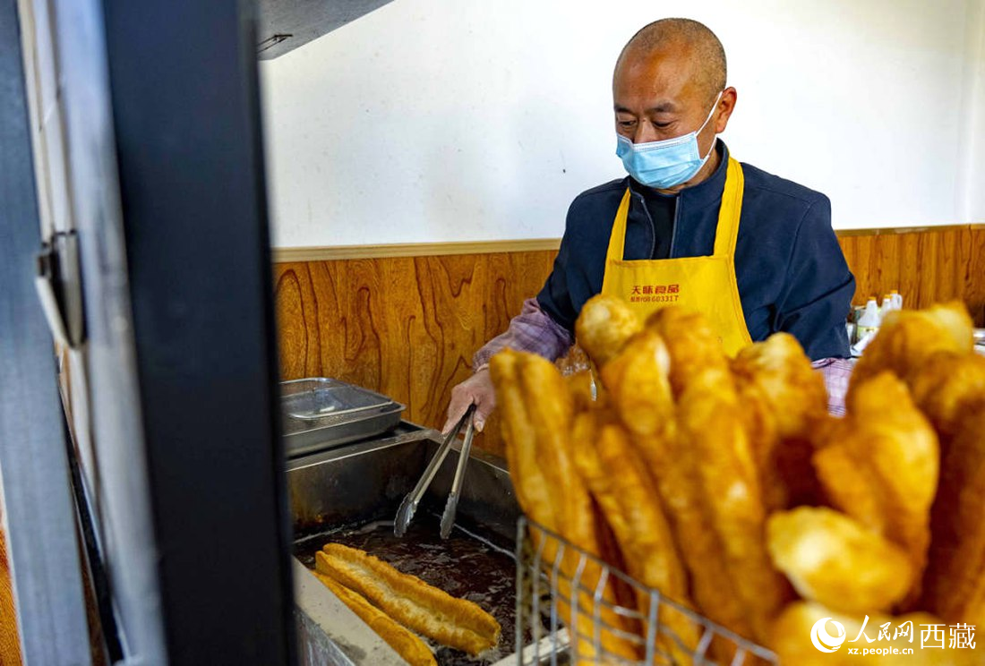 早餐店老板正在炸油條。人民網(wǎng) 次仁羅布攝