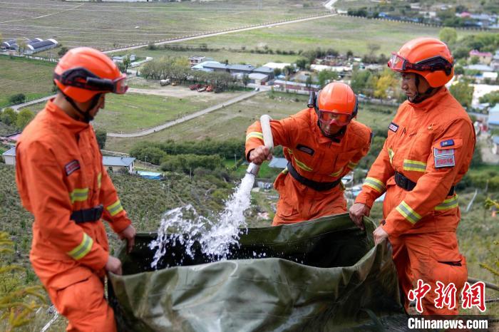 技能大練兵過程中，消防員在陡坡上向蓄水池注水?！±顕鵂c 攝