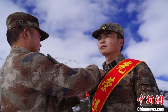 排長(zhǎng)王朝偉(圖左)給退伍老兵佩戴大紅花?！∥鞑厣侥宪姺謪^(qū)某團(tuán)供圖