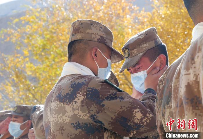 圖為什布奇邊防連退伍老兵與戰(zhàn)友相擁而泣，依依惜別?！⌒觳?攝
