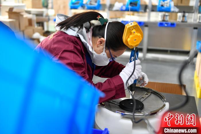 圖為工人正在組裝炊具。　貢嘎來松 攝
