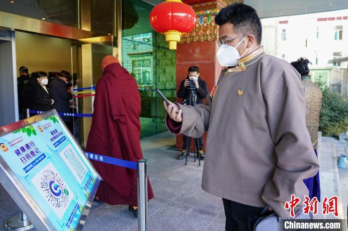 圖為政協(xié)委員掃場所碼進(jìn)入會場?！〗w波 攝