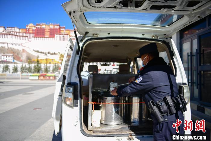 圖為1月23日，布達(dá)拉宮廣場派出所民警正在打午飯?！∝暩聛硭?攝