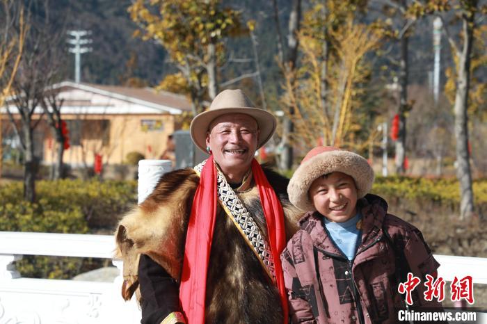 圖為林芝市巴宜區(qū)布久鄉(xiāng)仲果村村民桑杰與孫子一起參加藏歷新年活動(dòng)?！埩?攝
