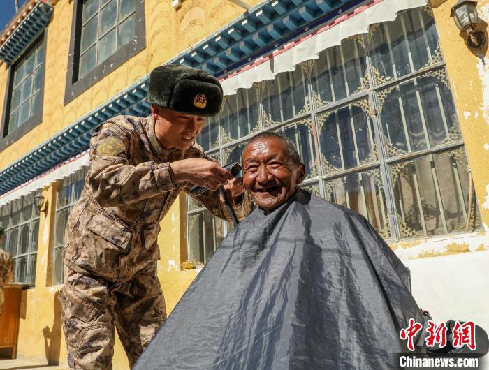 圖為阿里軍分區(qū)某邊防團(tuán)官兵為駐地群眾理發(fā)迎藏歷新年?！〉┰鰝愔?攝