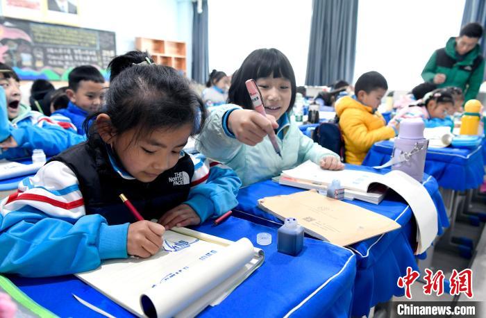 3月14日，西藏拉薩市第一小學一年級六班學生白瑪朗珍(圖左)在藏語文課上書寫藏文?！±盍?攝