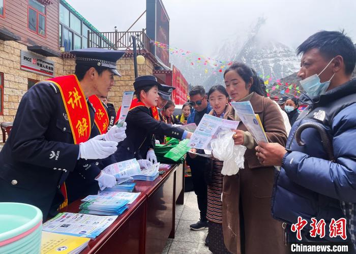 圖為山南玉麥邊境派出所民警為轄區(qū)群眾發(fā)放法律知識(shí)宣傳單?！＄婗?　攝