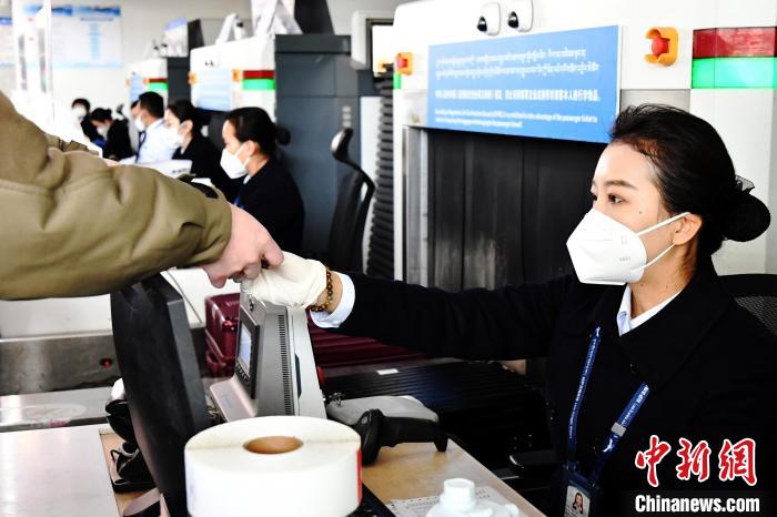 圖為機場工作人員為旅客辦理行李托運?！≈芎?攝