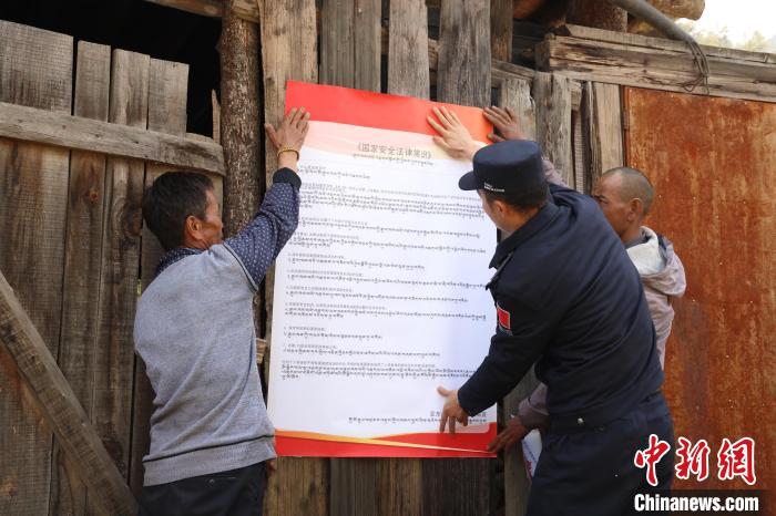圖為亞東邊檢站民警與駐地邊民群眾共同張貼國(guó)家安全知識(shí)教育海報(bào)?！問|邊檢站 供圖