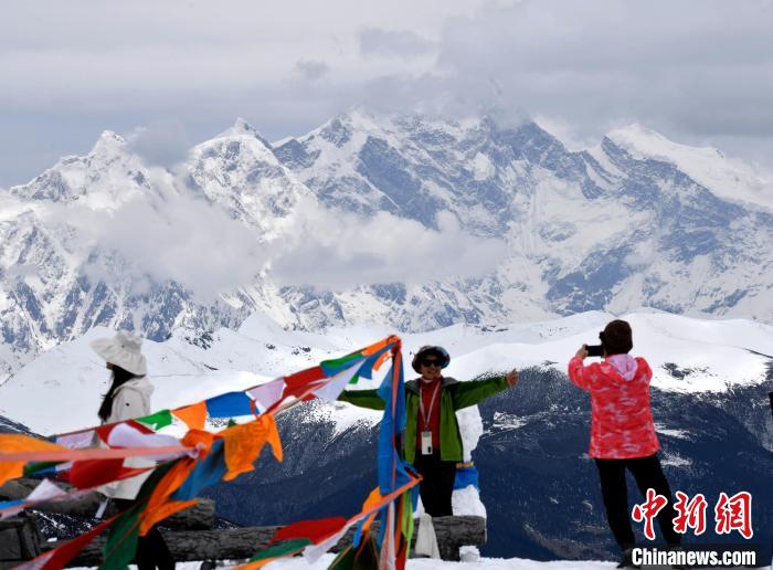 圖為5月14日，西藏林芝色季拉山觀景臺(tái)，游客與南迦巴瓦峰合影。　李林 攝