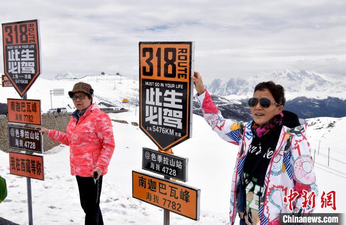 圖為5月14日，西藏林芝色季拉山觀景臺(tái)，游客與南迦巴瓦峰合影?！±盍?攝