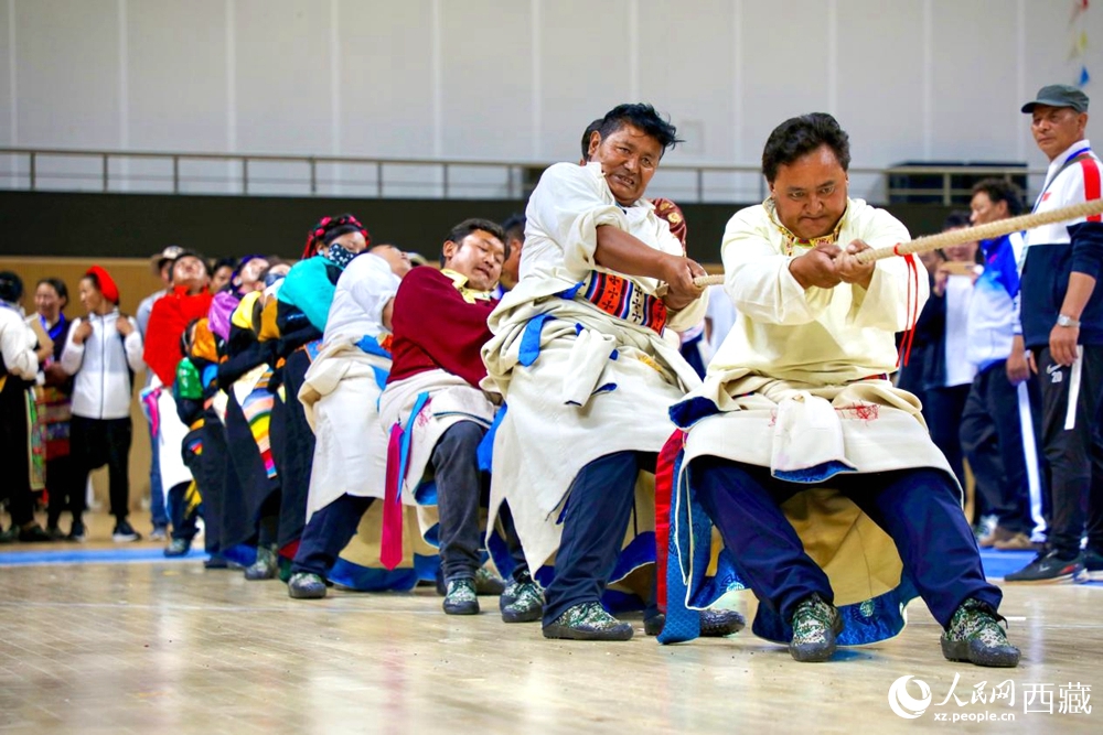 身著民族服裝的農(nóng)牧民選手在拔河比賽現(xiàn)場。
